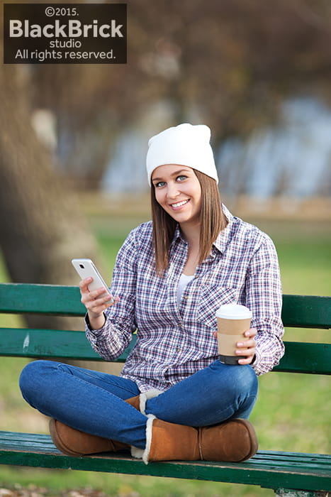 Photo of young beautiful woman having coffee in park