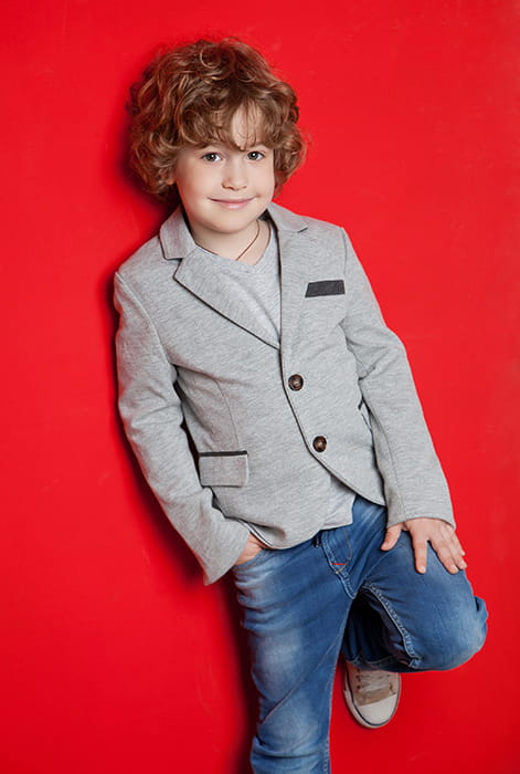 Studio photo of a cute kid on red background